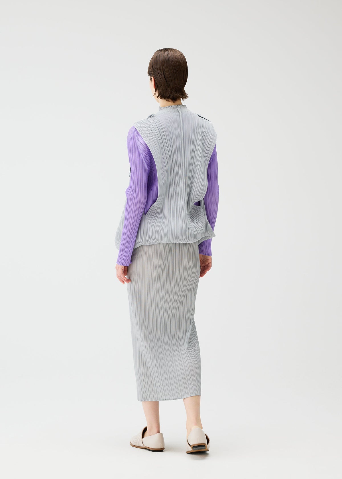 A model wears the Pleats Please Issey Miyake SWING cardigan.