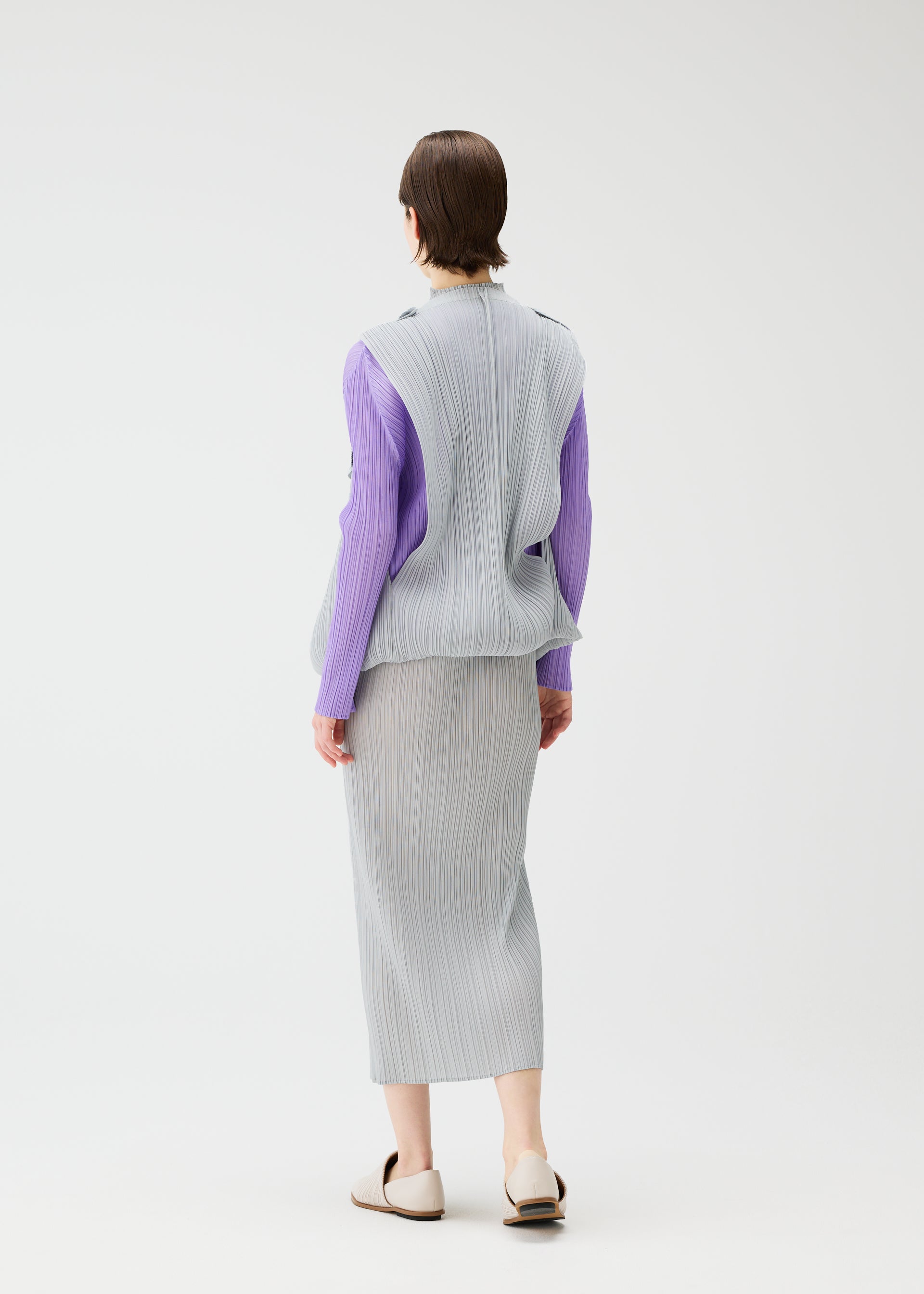 A model wears the Pleats Please Issey Miyake SWING cardigan.