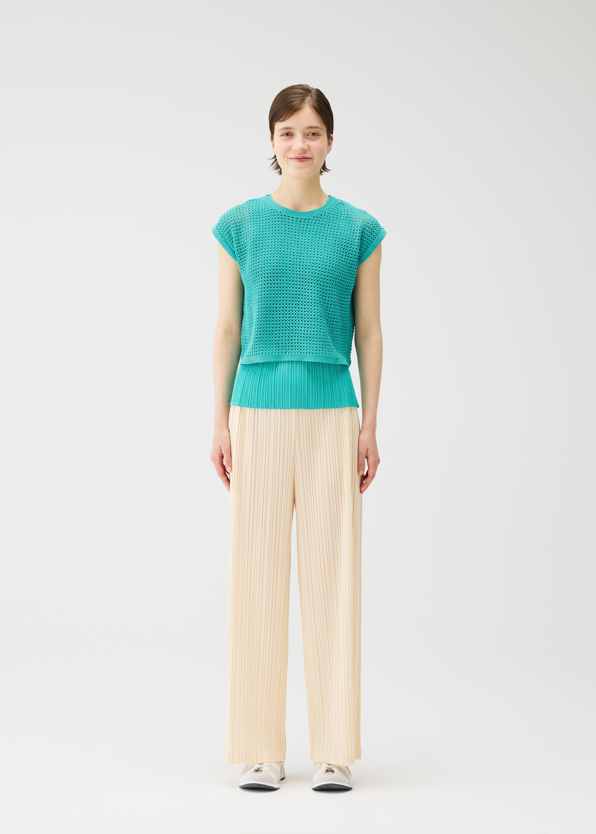 A model wears the Pleats Please Issey Miyake FISHNET KNIT vest.