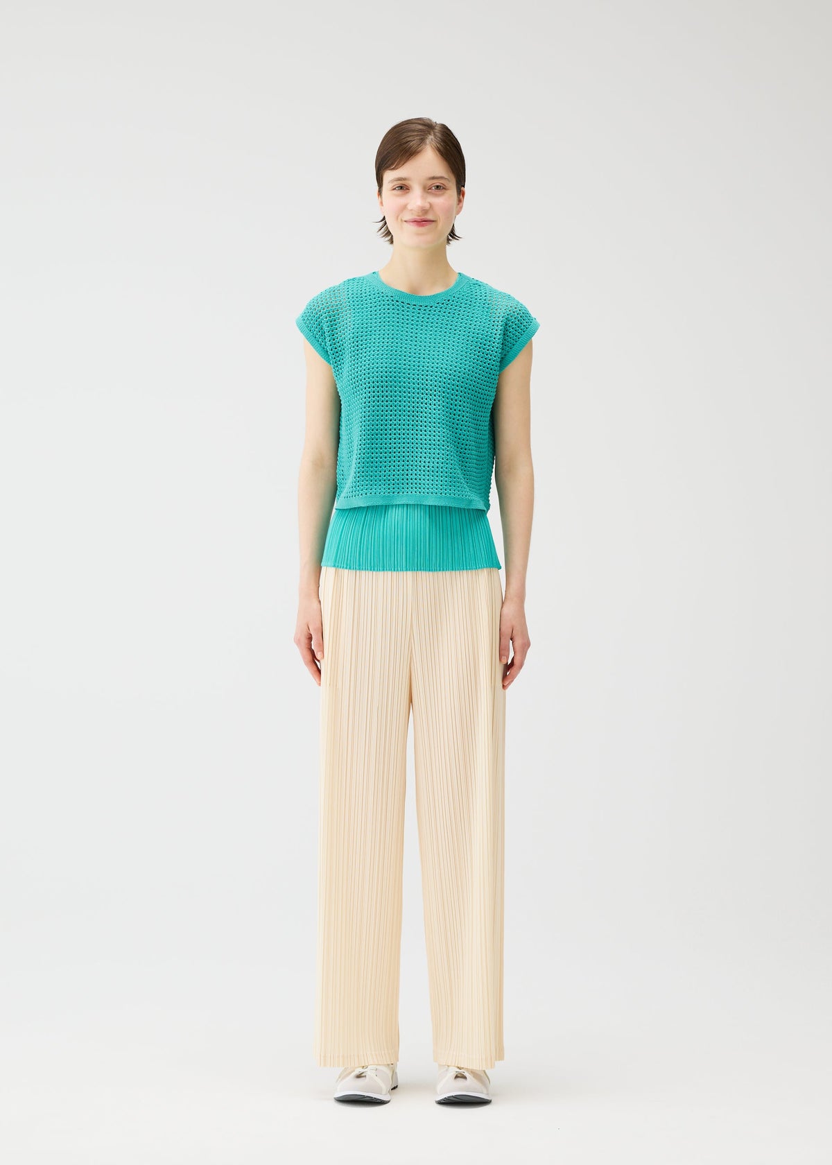 A model wears the Pleats Please Issey Miyake FISHNET KNIT vest.