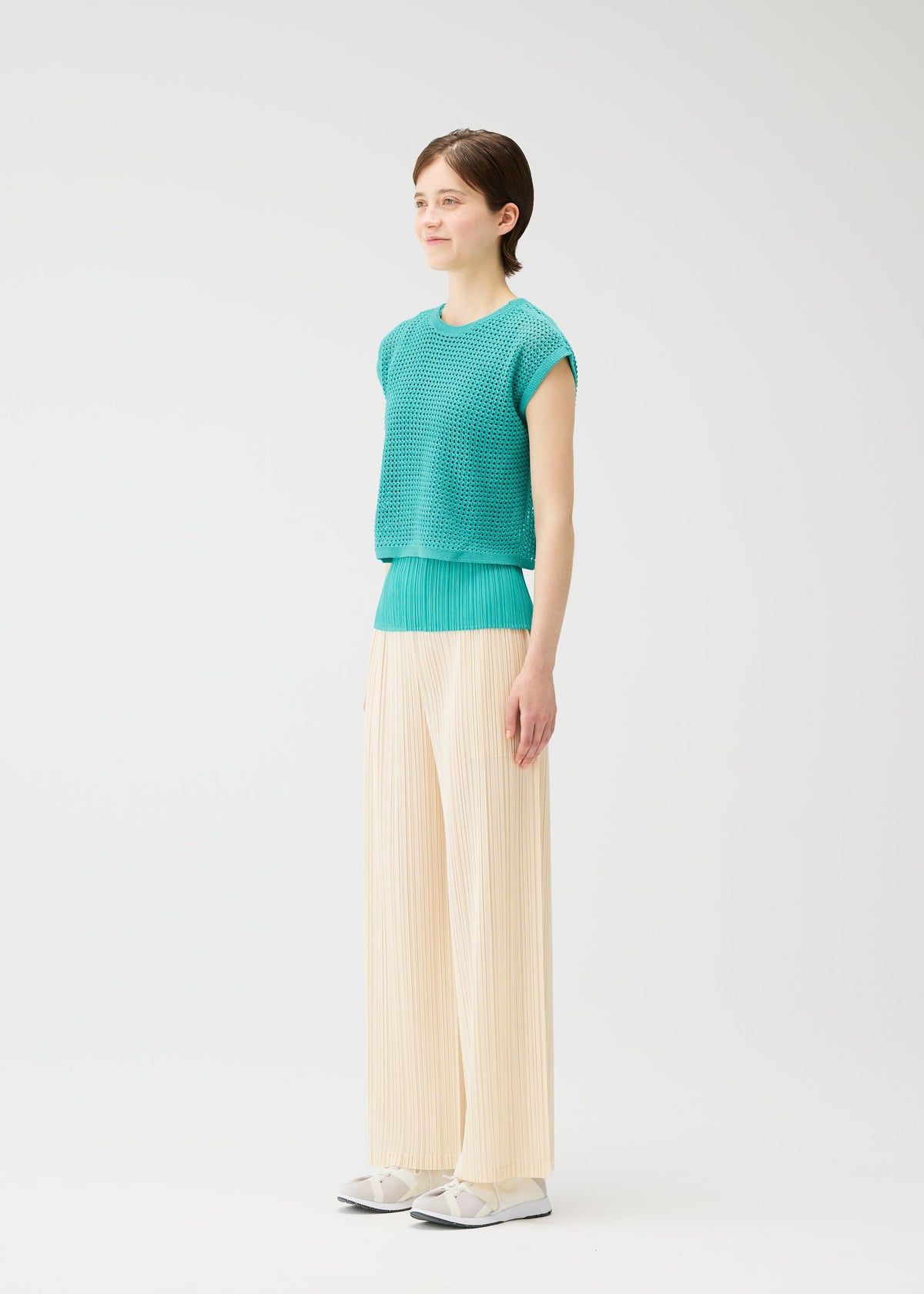 A model wears the Pleats Please Issey Miyake FISHNET KNIT vest.