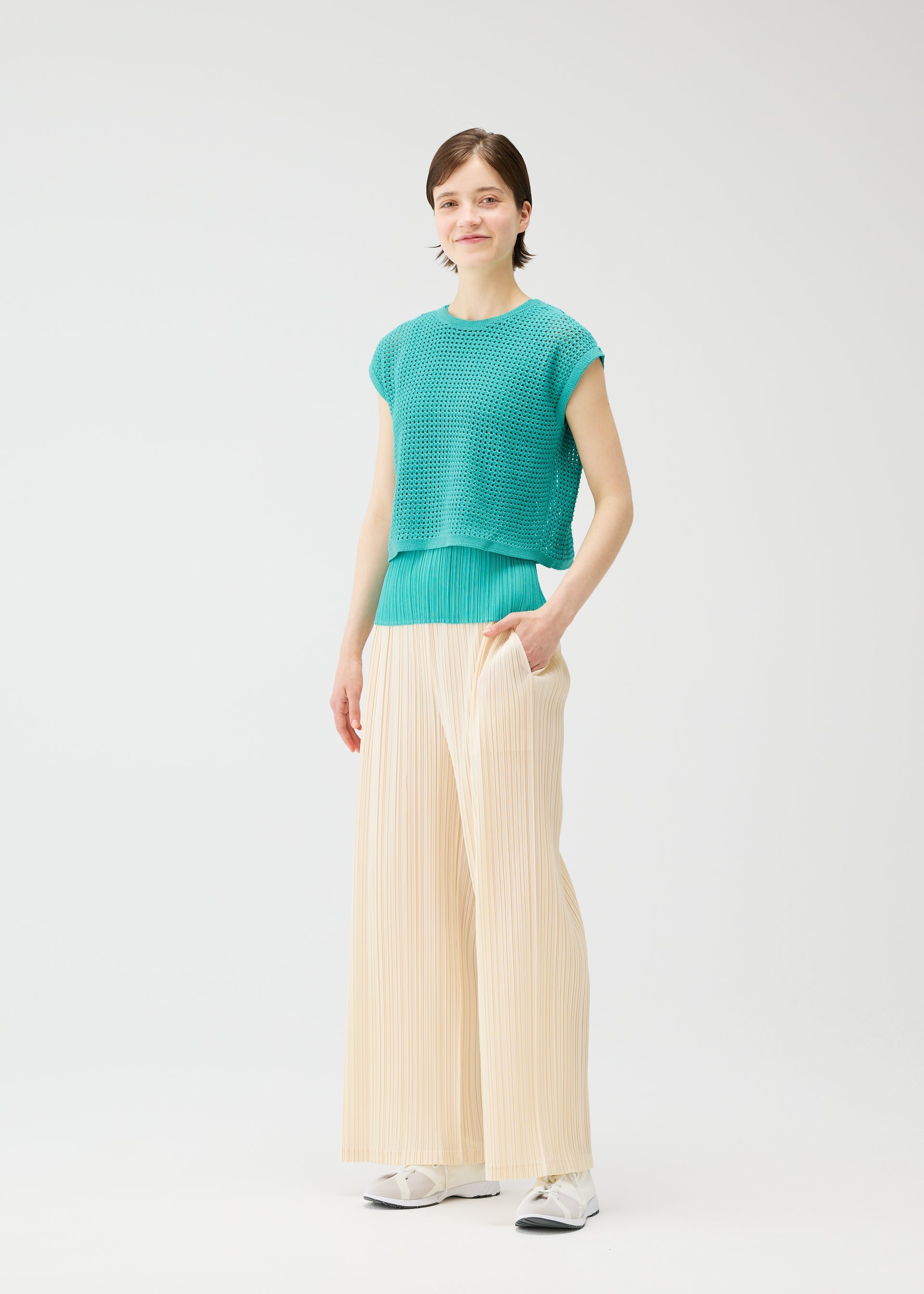 A model wears the Pleats Please Issey Miyake FISHNET KNIT vest.