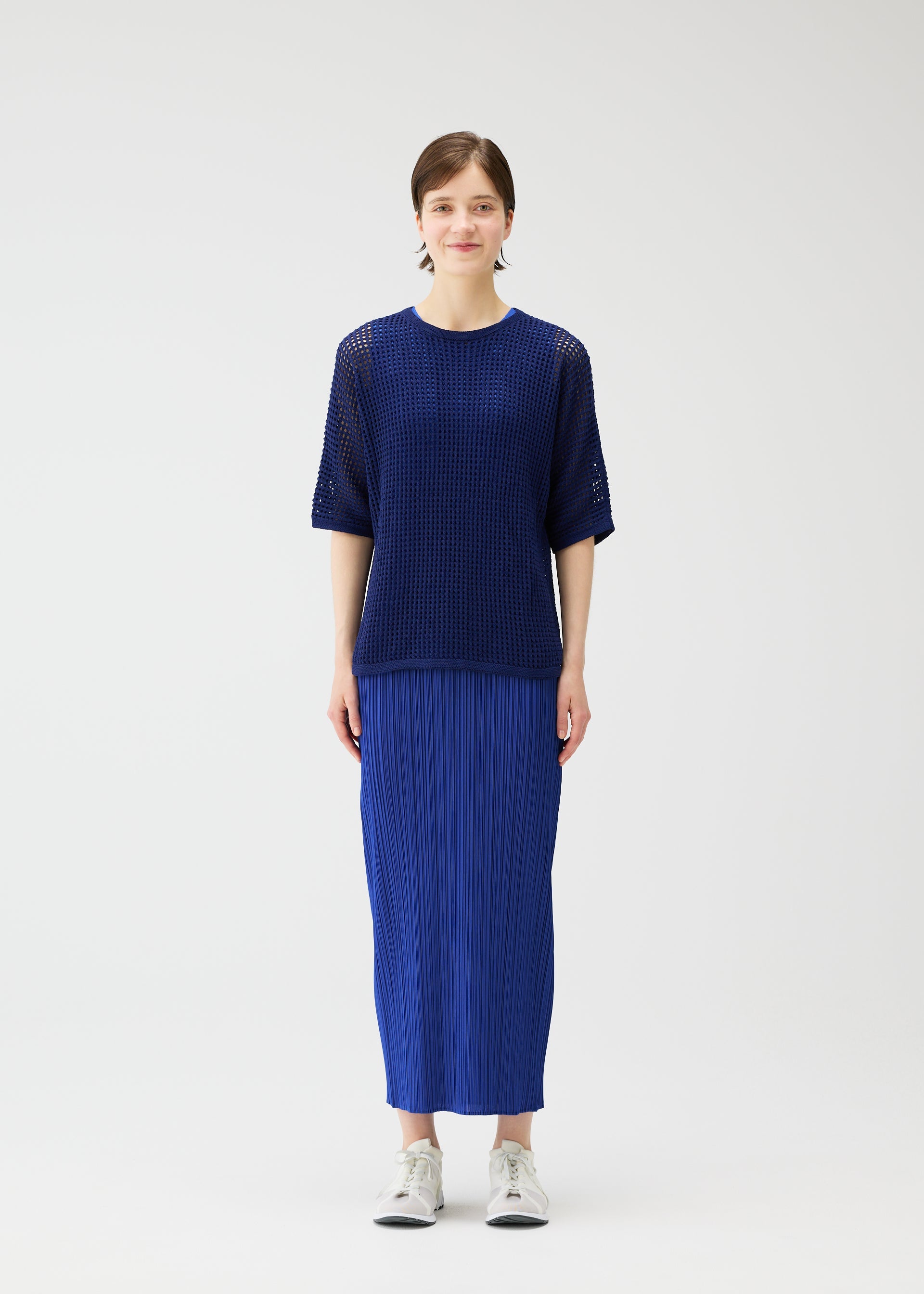A model wears the Pleats Please Issey Miyake FISHNET KNIT shirt.
