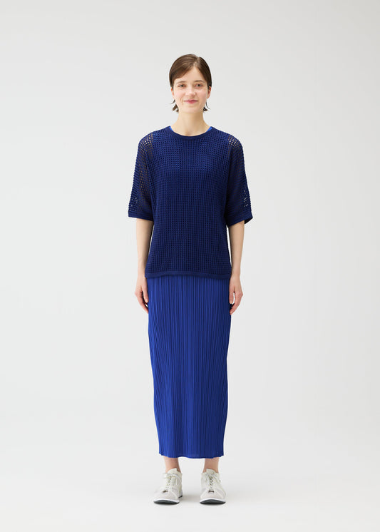 A model wears the Pleats Please Issey Miyake FISHNET KNIT shirt.
