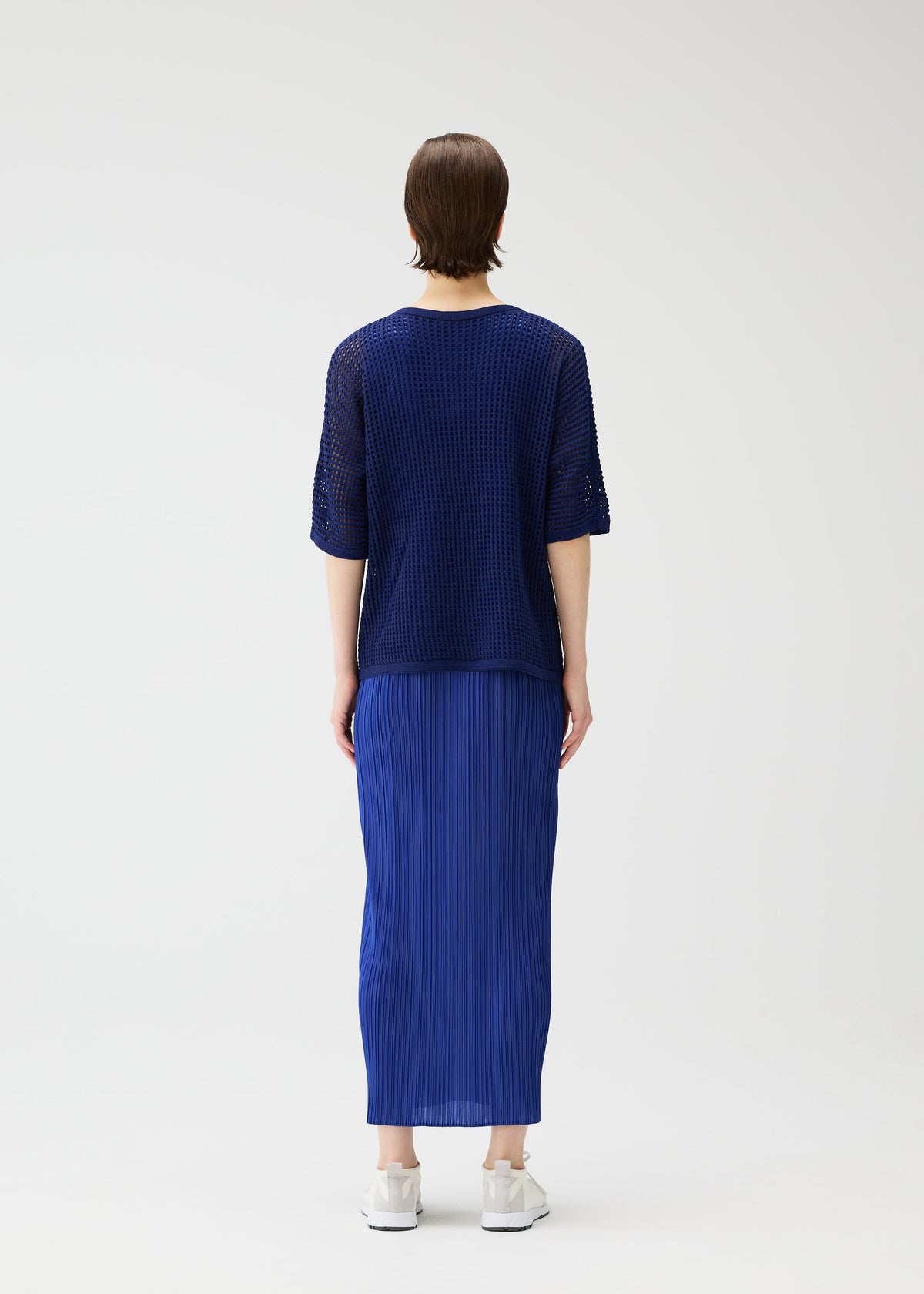 A model wears the Pleats Please Issey Miyake FISHNET KNIT shirt.