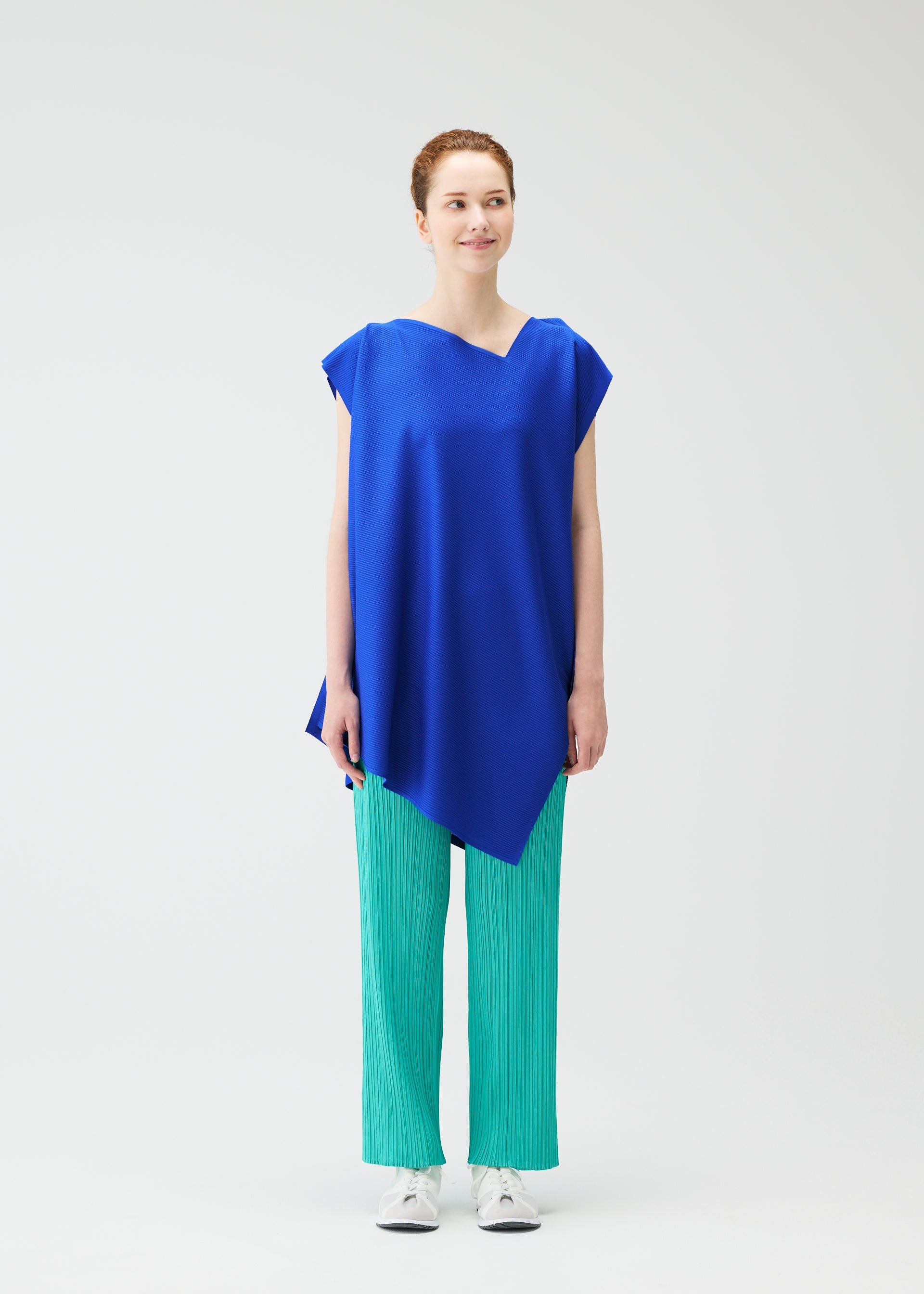 A model wears the Pleats Please Issey Miyake A POC SEA GLASS shirt.