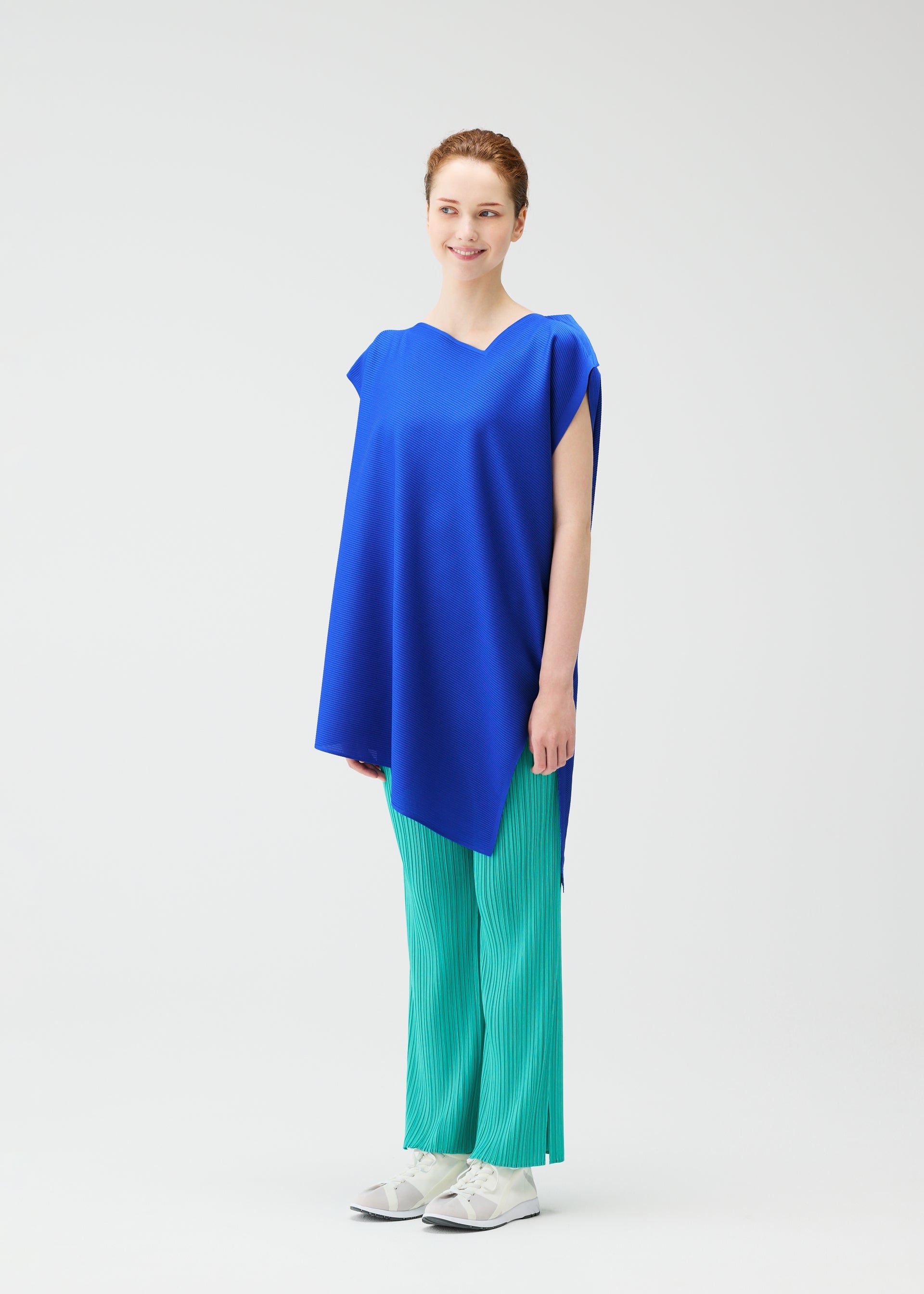 A model wears the Pleats Please Issey Miyake A POC SEA GLASS shirt.