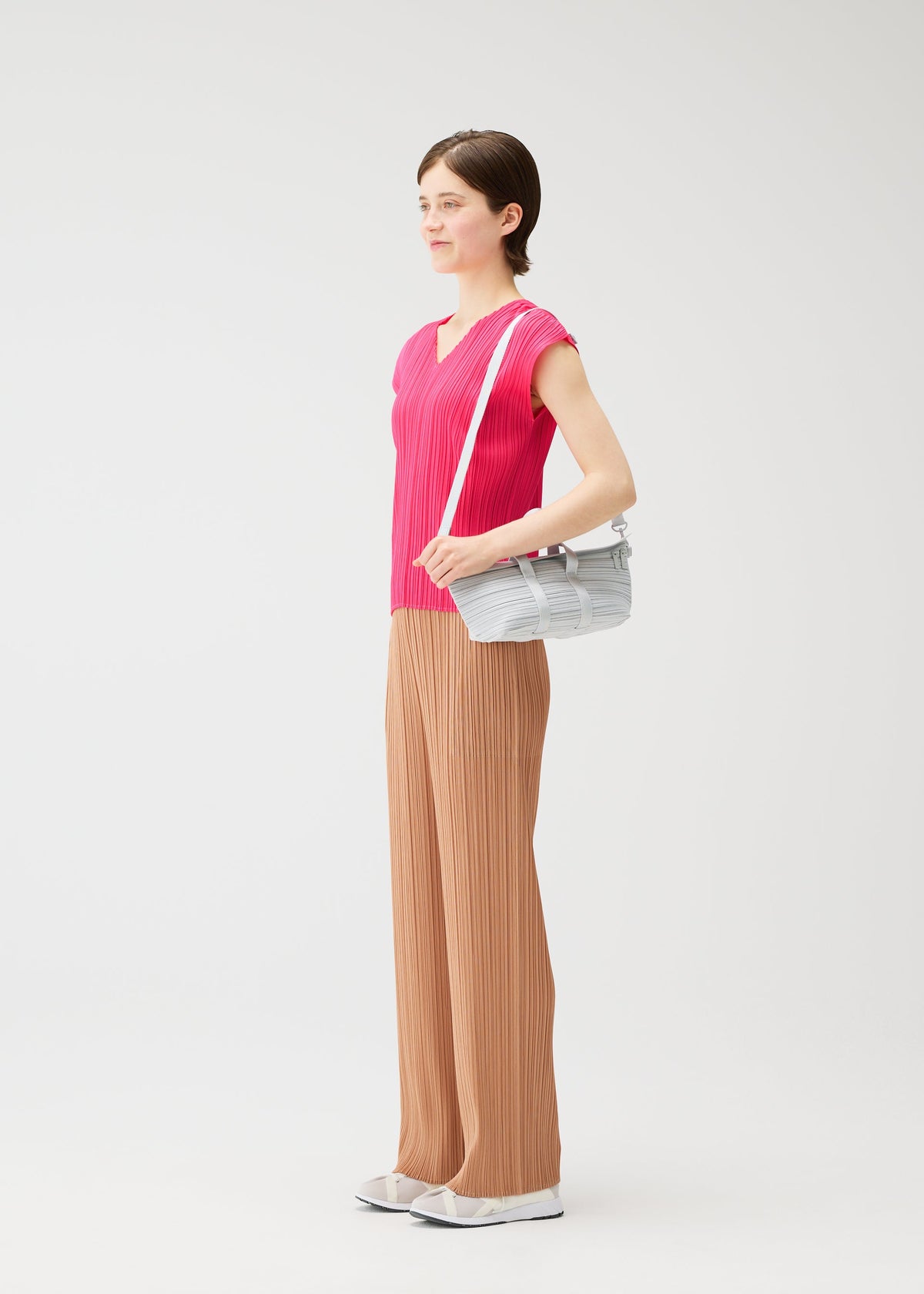 A model wears the PLEATS PLEASE ISSEY MIYAKE PLEATS BOSTON BAG pleats-boston-bag-bag-yellow-green.