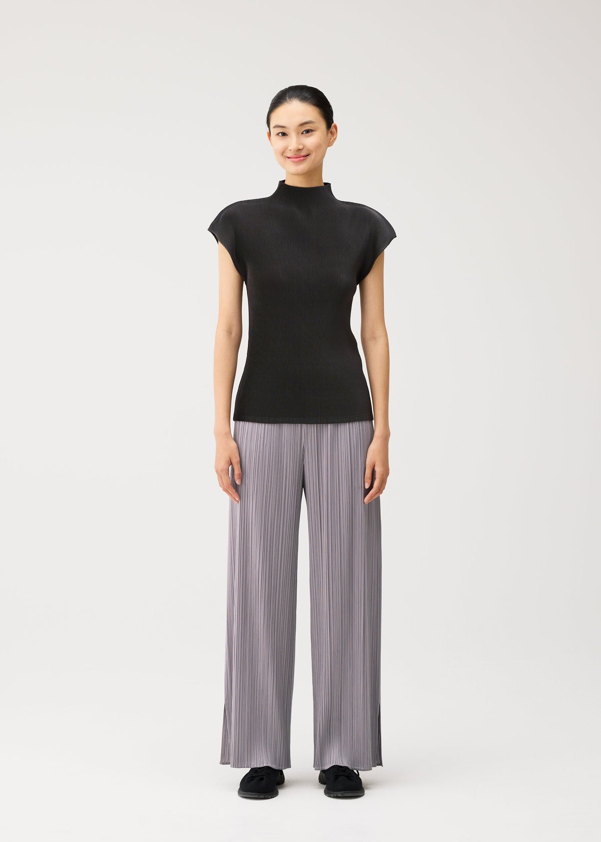 A model wears the PLEATS PLEASE ISSEY MIYAKE MIST AUGUST mist-august-shirt-greyish-green.