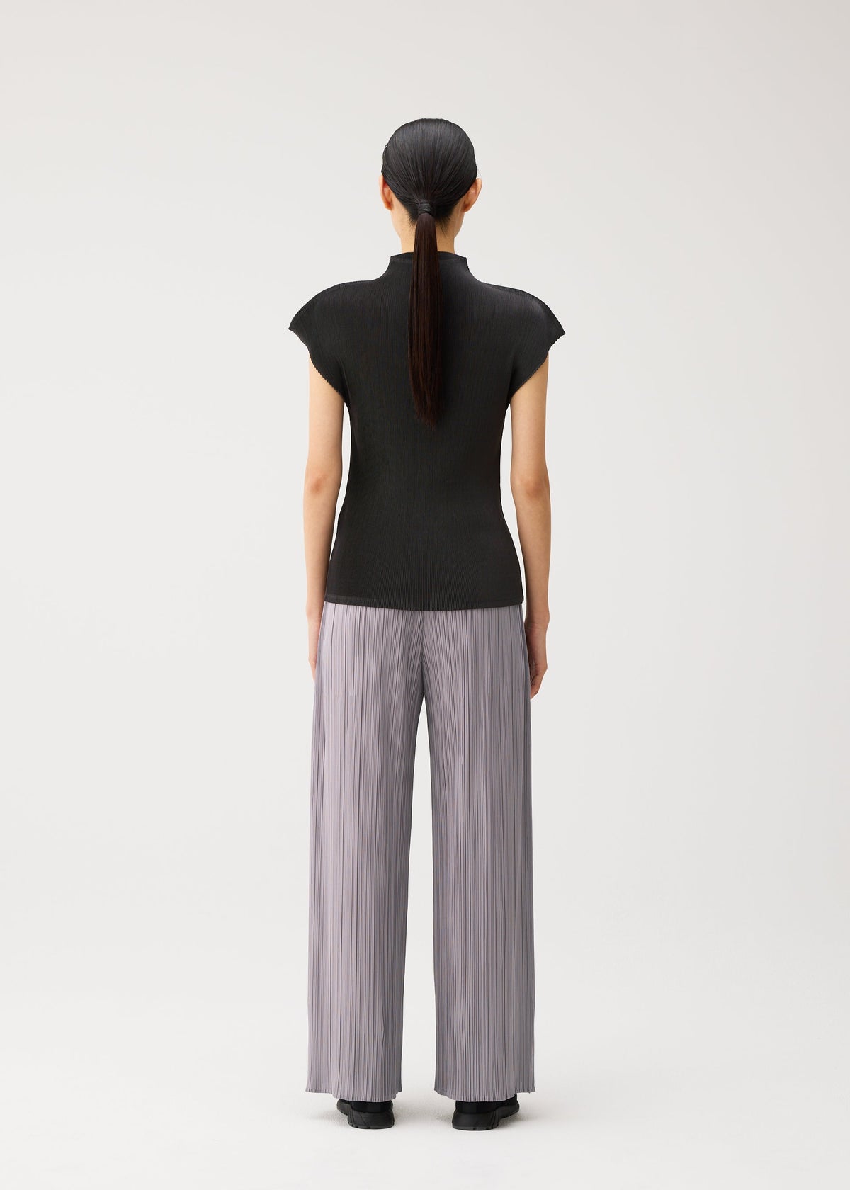 A model wears the PLEATS PLEASE ISSEY MIYAKE MIST AUGUST mist-august-shirt-charcoal.