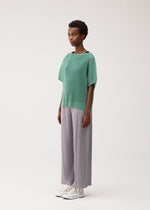 A model wears the PLEATS PLEASE ISSEY MIYAKE TATAMI AUGUST tatami-august-shirt-greyish-green.