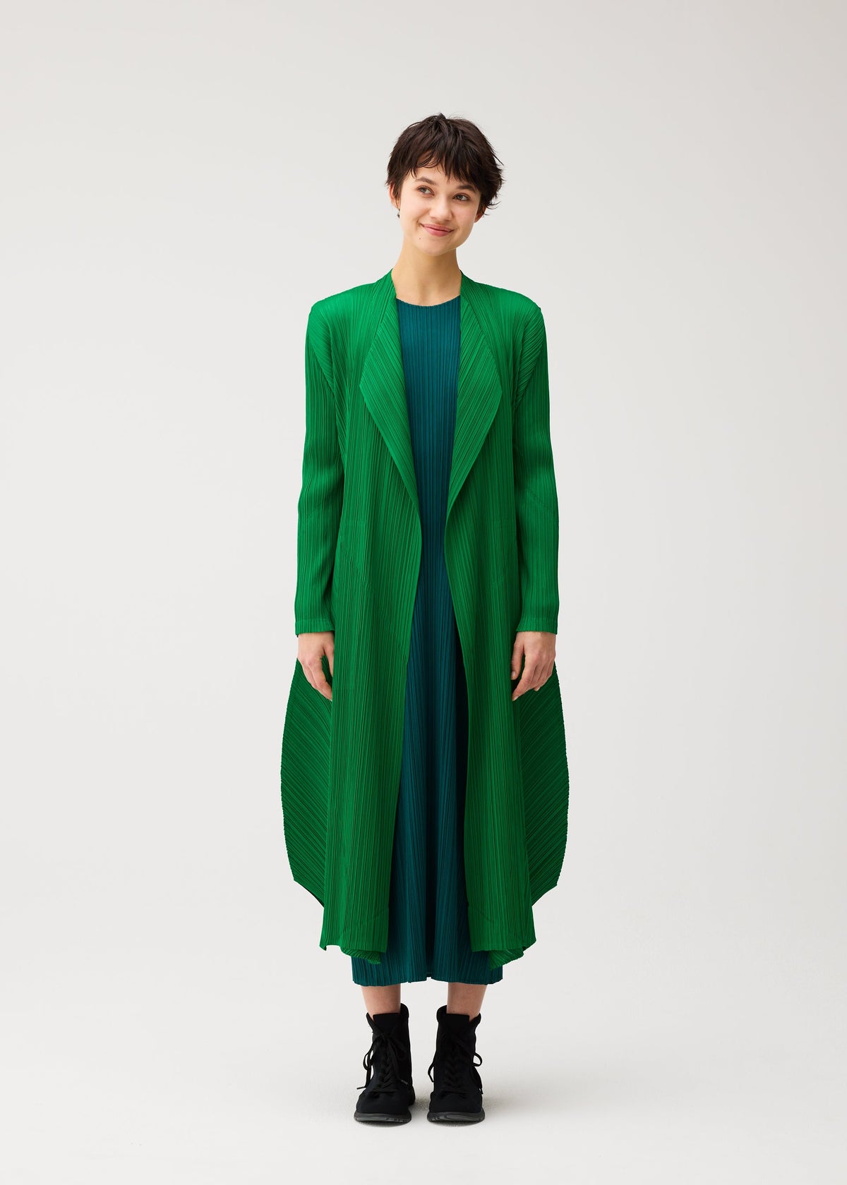 A model wears the PLEATS PLEASE ISSEY MIYAKE MONTHLY COLORS : OCTOBER coat.