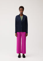 A model wears the PLEATS PLEASE ISSEY MIYAKE PLEATS JACKET jacket.