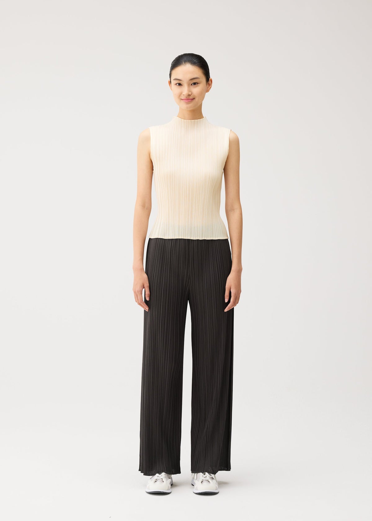 A model wears the PLEATS PLEASE ISSEY MIYAKE MONTHLY COLORS : AUGUST monthly-colors-august-trousers-off-white.