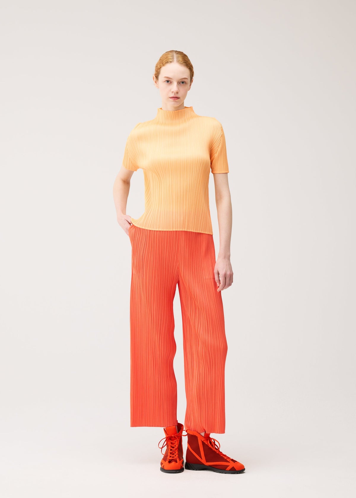 A model wears the PLEATS PLEASE ISSEY MIYAKE MONTHLY COLORS : SEPTEMBER trousers.