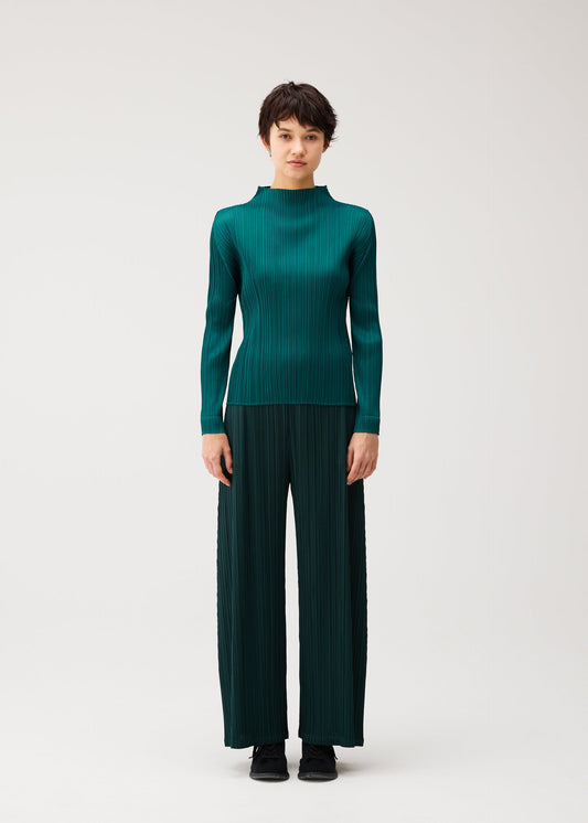 A model wears the PLEATS PLEASE ISSEY MIYAKE MONTHLY COLORS : OCTOBER monthly-colors-october-pants-yellow-ochre.