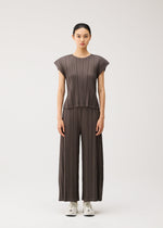 A model wears the PLEATS PLEASE ISSEY MIYAKE MELLOW PLEATS trousers.