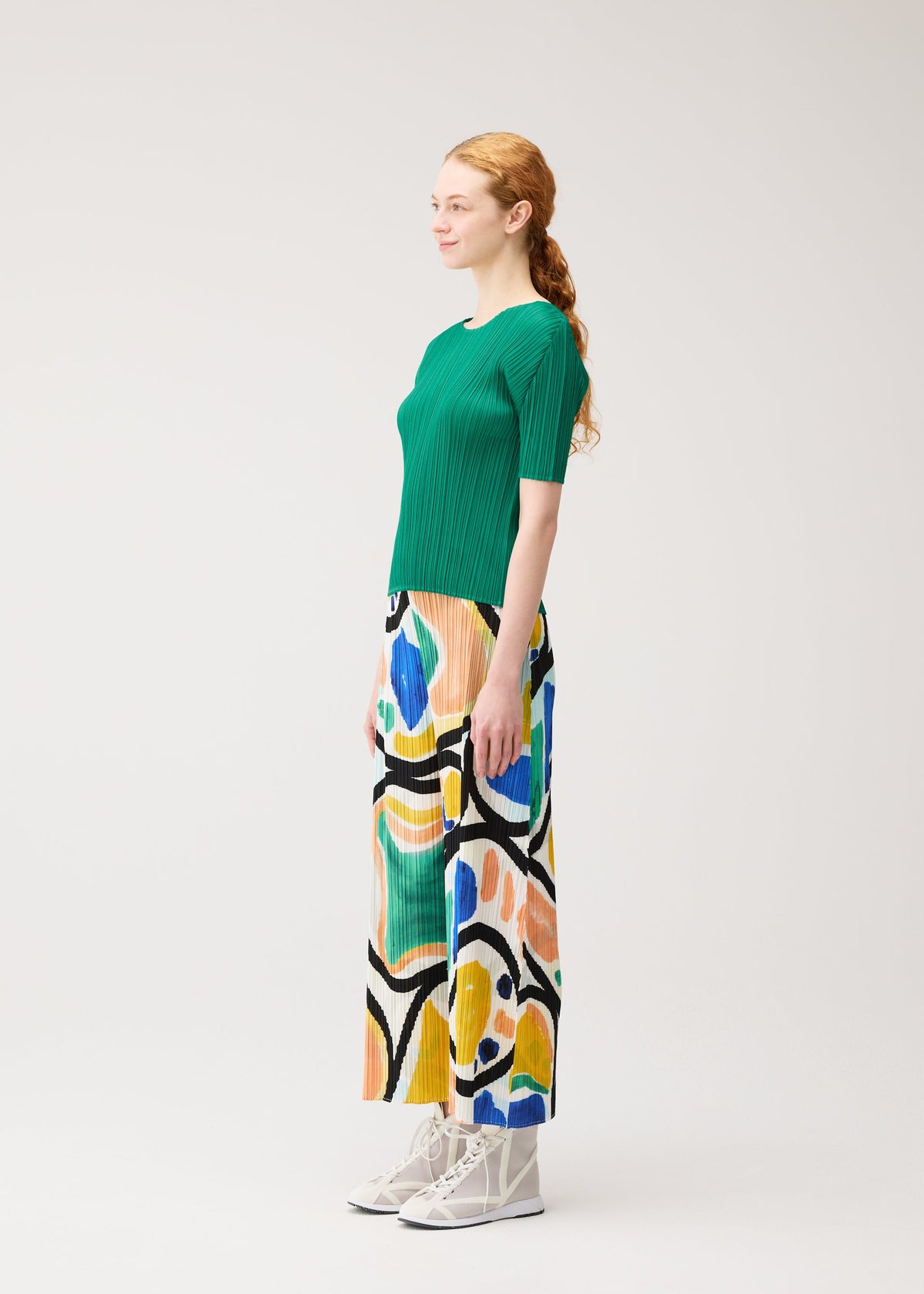 A model wears the PLEATS PLEASE ISSEY MIYAKE ROLL roll-trousers-multi-1.