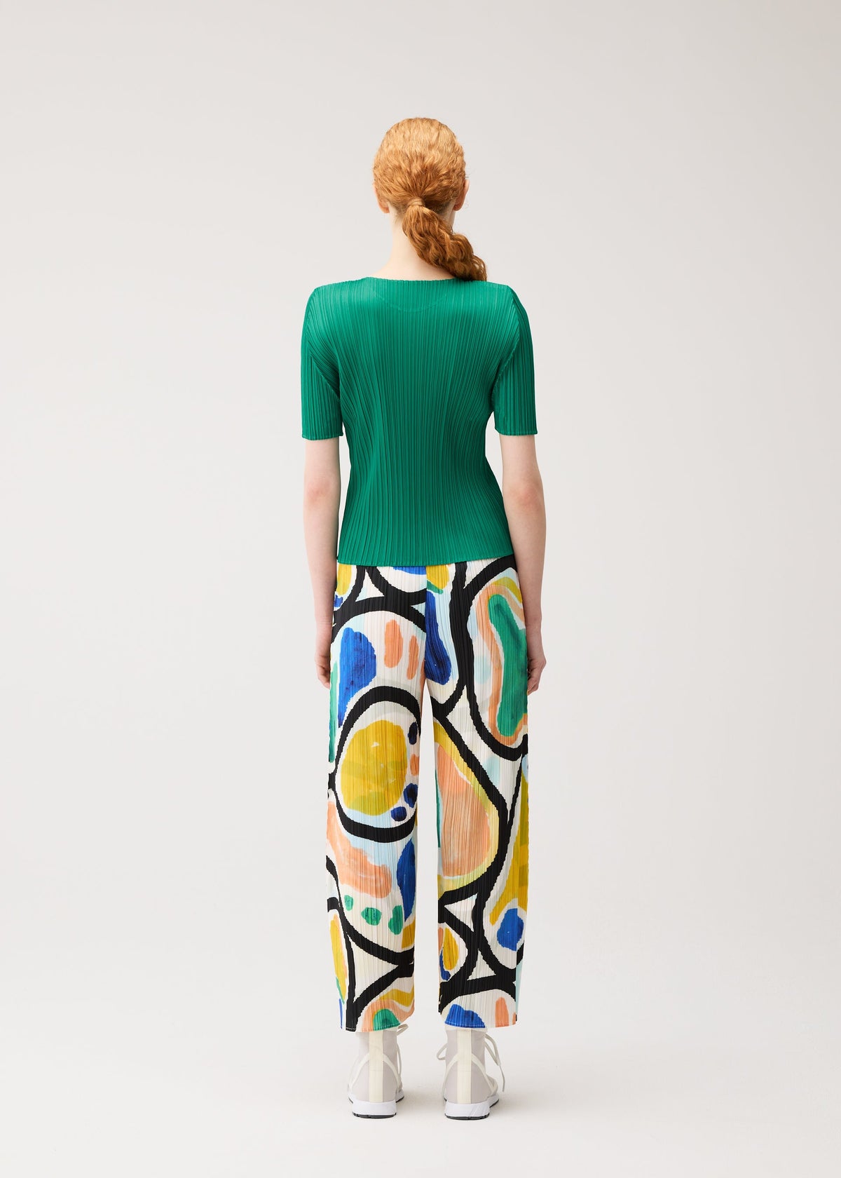 A model wears the PLEATS PLEASE ISSEY MIYAKE ROLL roll-trousers-light-blue.