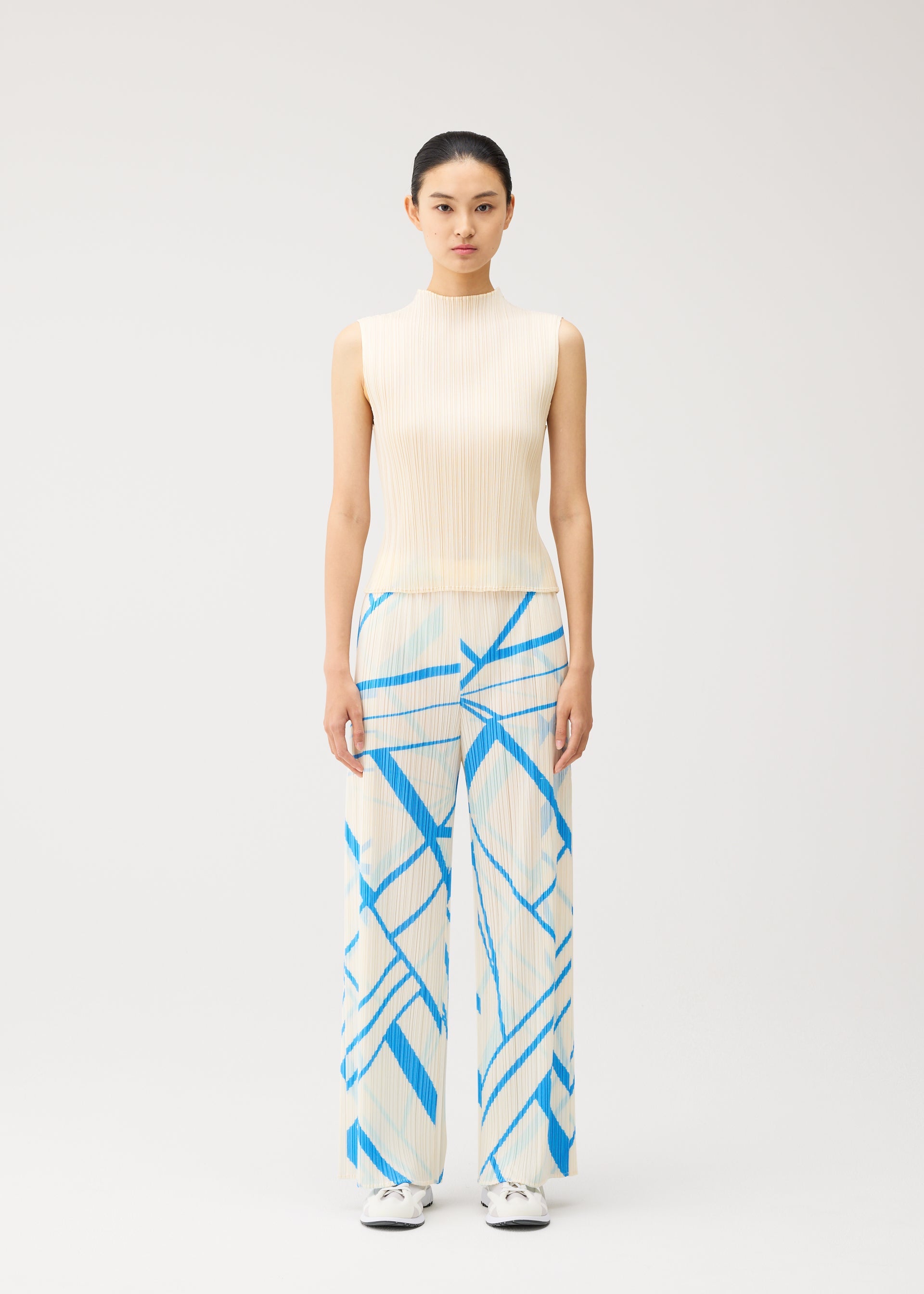 A model wears the PLEATS PLEASE ISSEY MIYAKE FOLD LINE fold-line-trousers-charcoal.
