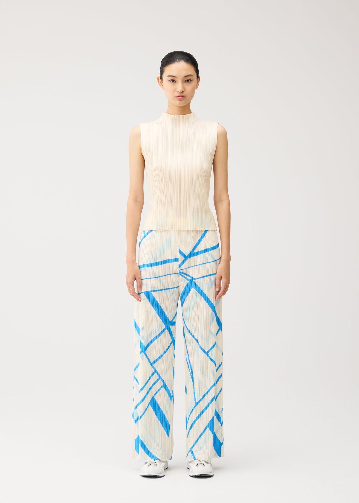 A model wears the PLEATS PLEASE ISSEY MIYAKE FOLD LINE fold-line-trousers-off-white.