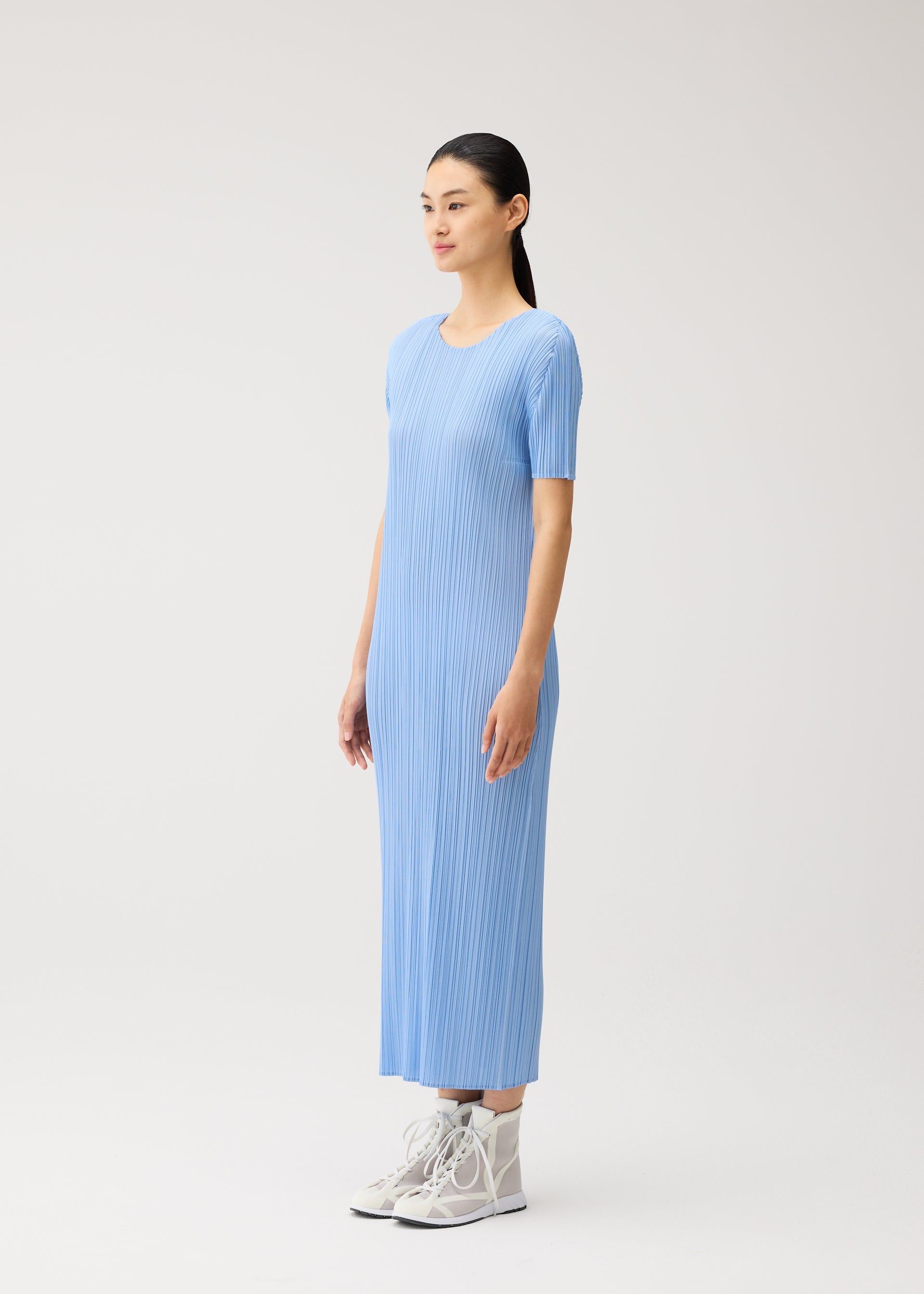 A model wears the PLEATS PLEASE ISSEY MIYAKE MONTHLY COLORS : AUGUST monthly-colors-dress-off-white.