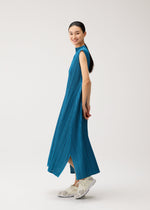 A model wears the PLEATS PLEASE ISSEY MIYAKE MELLOW PLEATS dress.