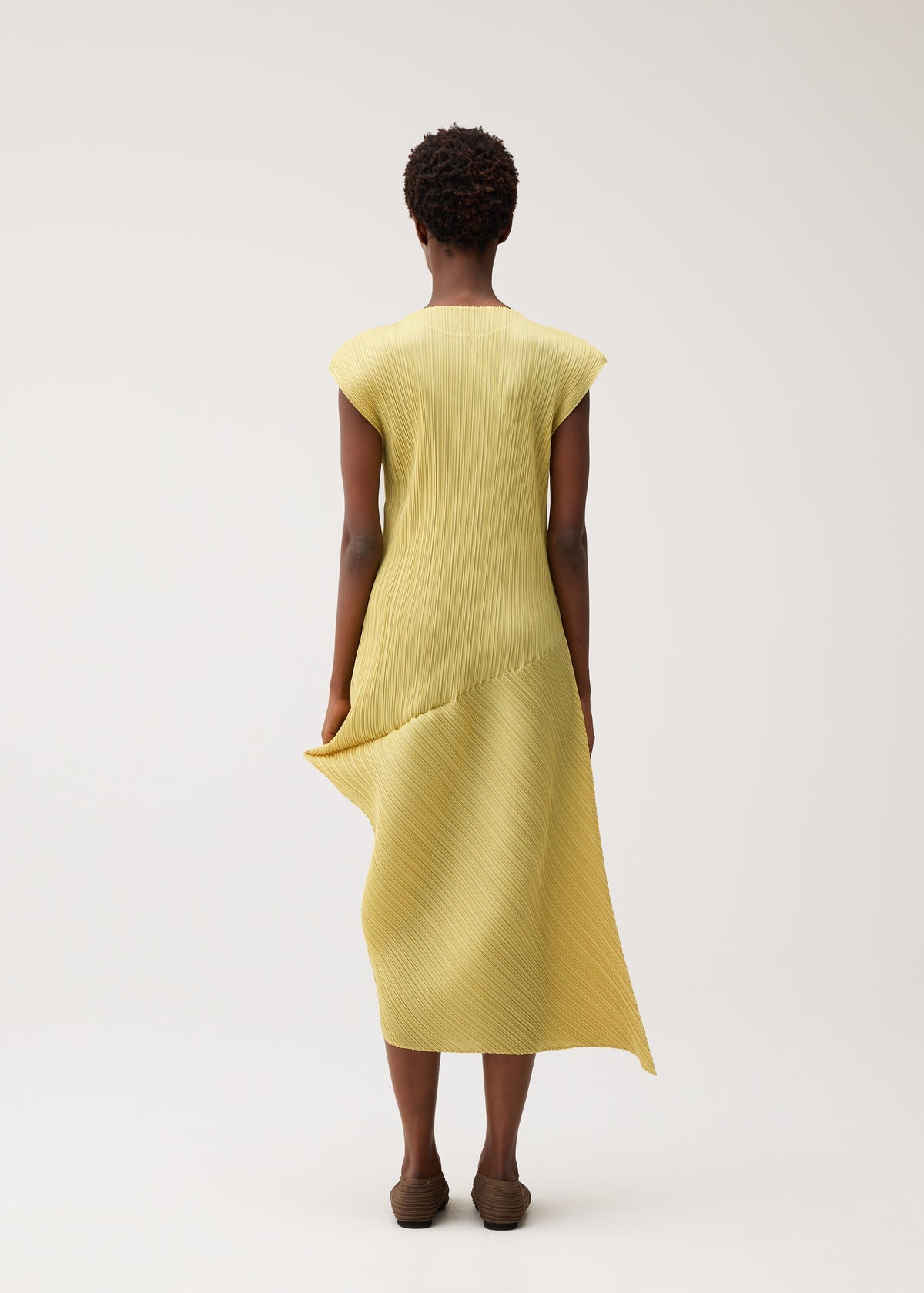 A model wears the PLEATS PLEASE ISSEY MIYAKE LEAP dress.