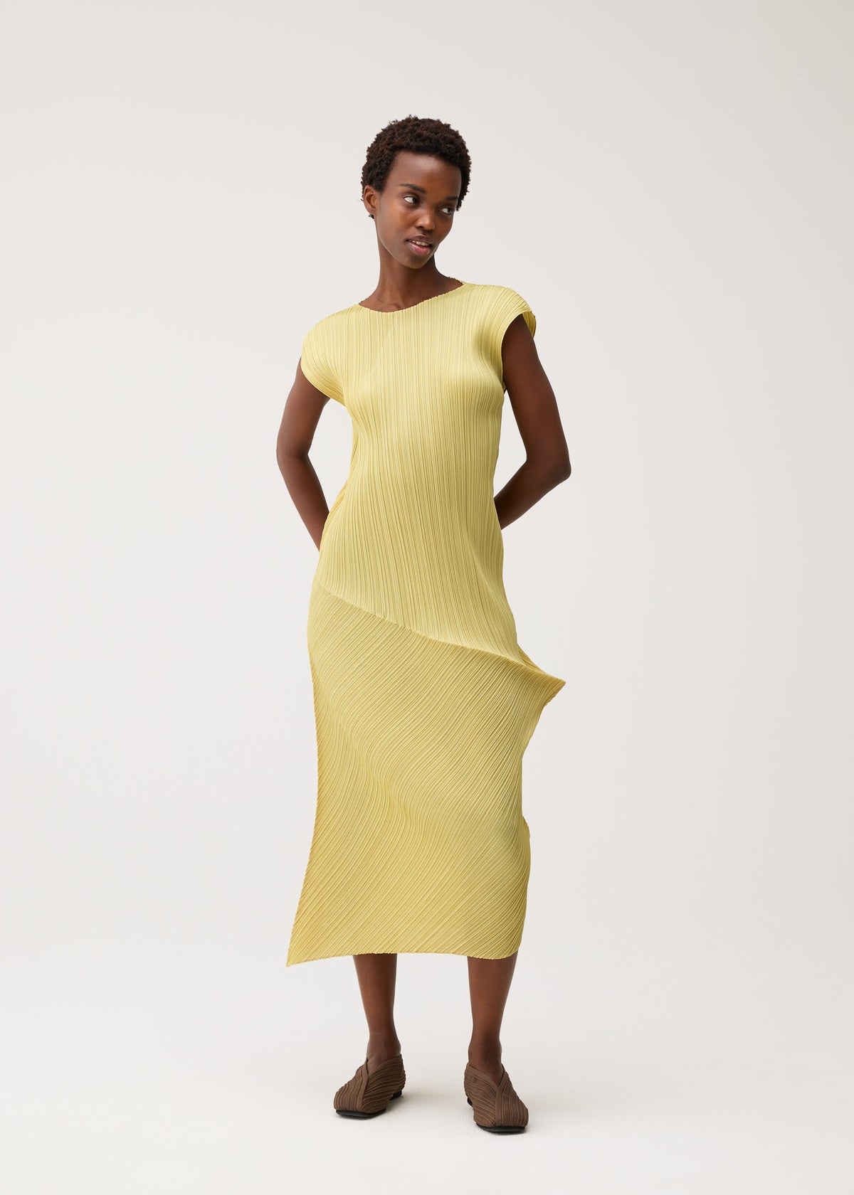A model wears the PLEATS PLEASE ISSEY MIYAKE LEAP dress.