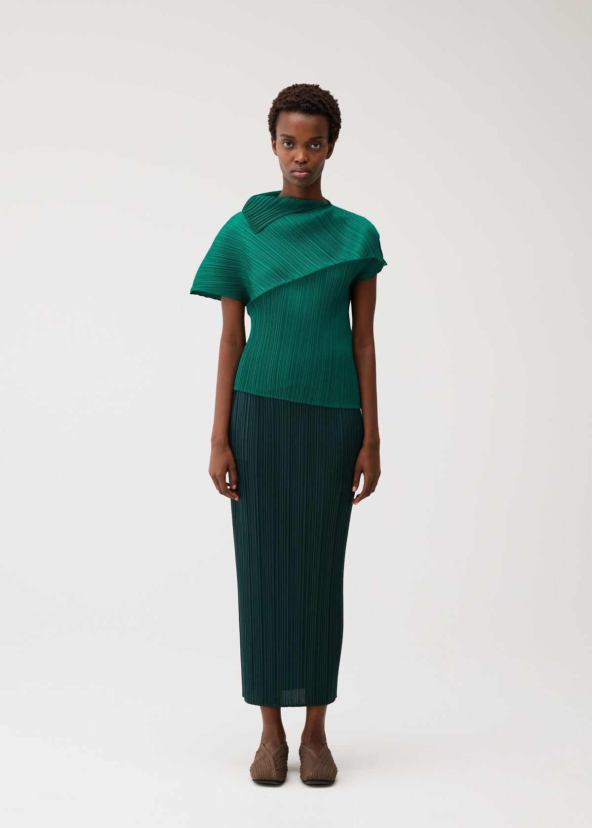 A model wears the PLEATS PLEASE ISSEY MIYAKE LEAP leap-shirt-forest-green.