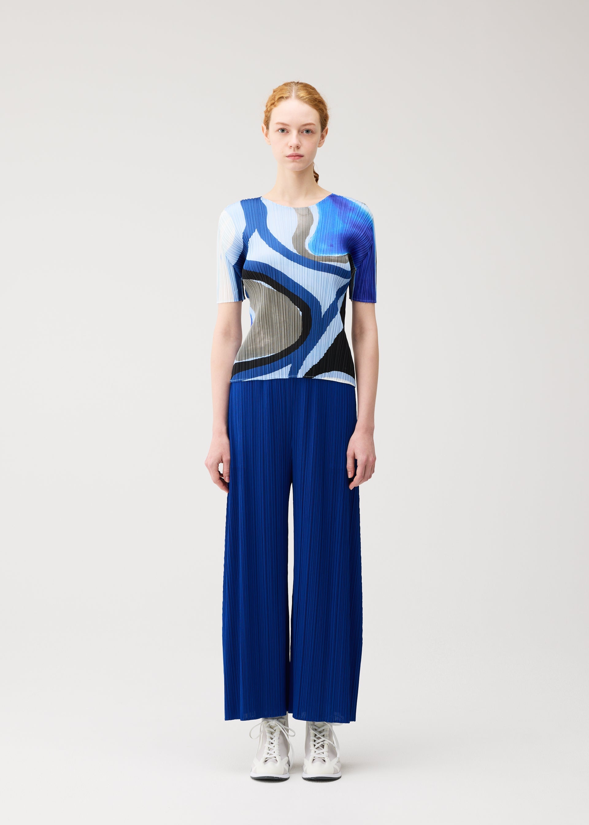 A model wears the PLEATS PLEASE ISSEY MIYAKE ROLL roll-shirt-light-blue.