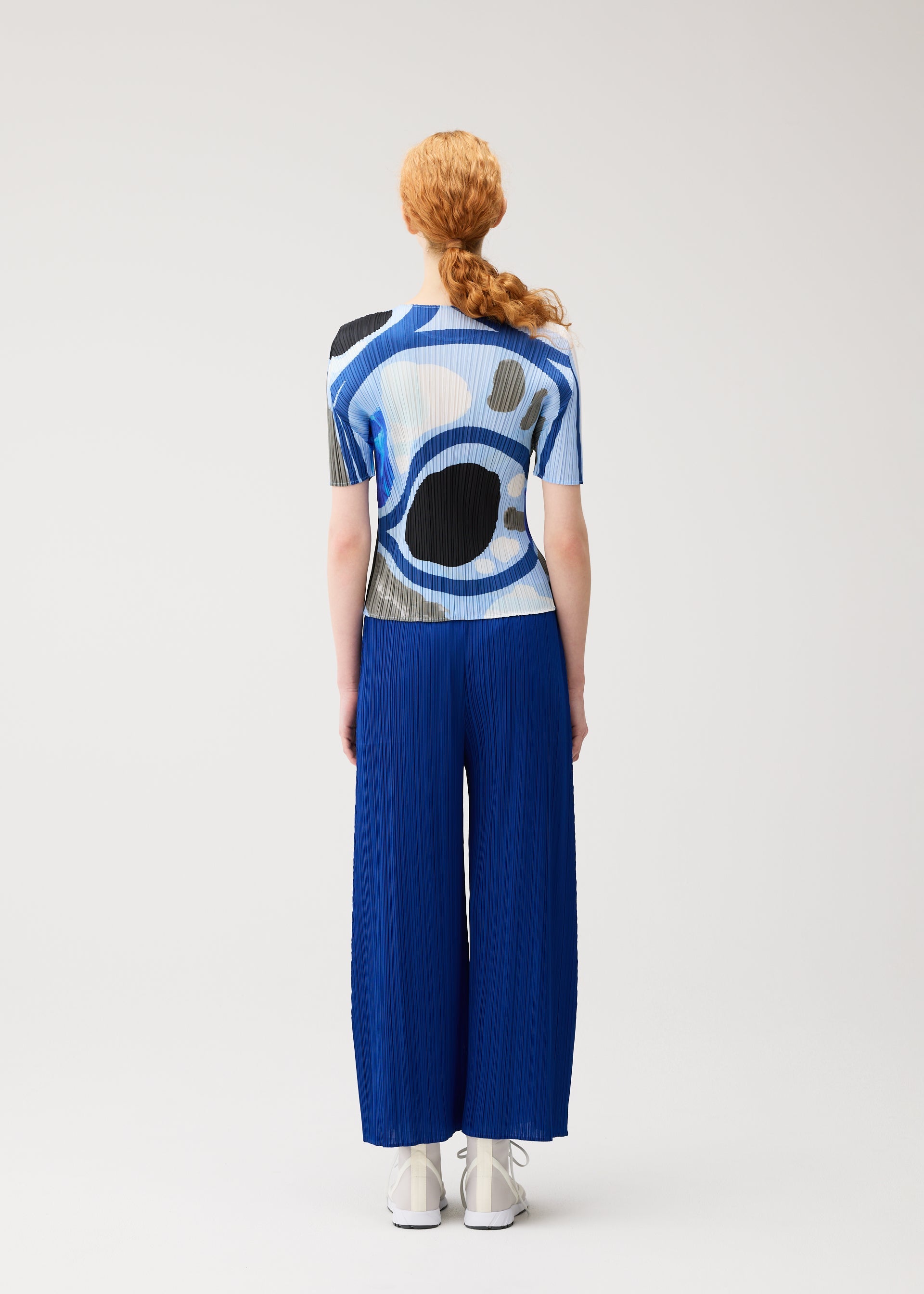 A model wears the PLEATS PLEASE ISSEY MIYAKE ROLL roll-shirt-multi-1.