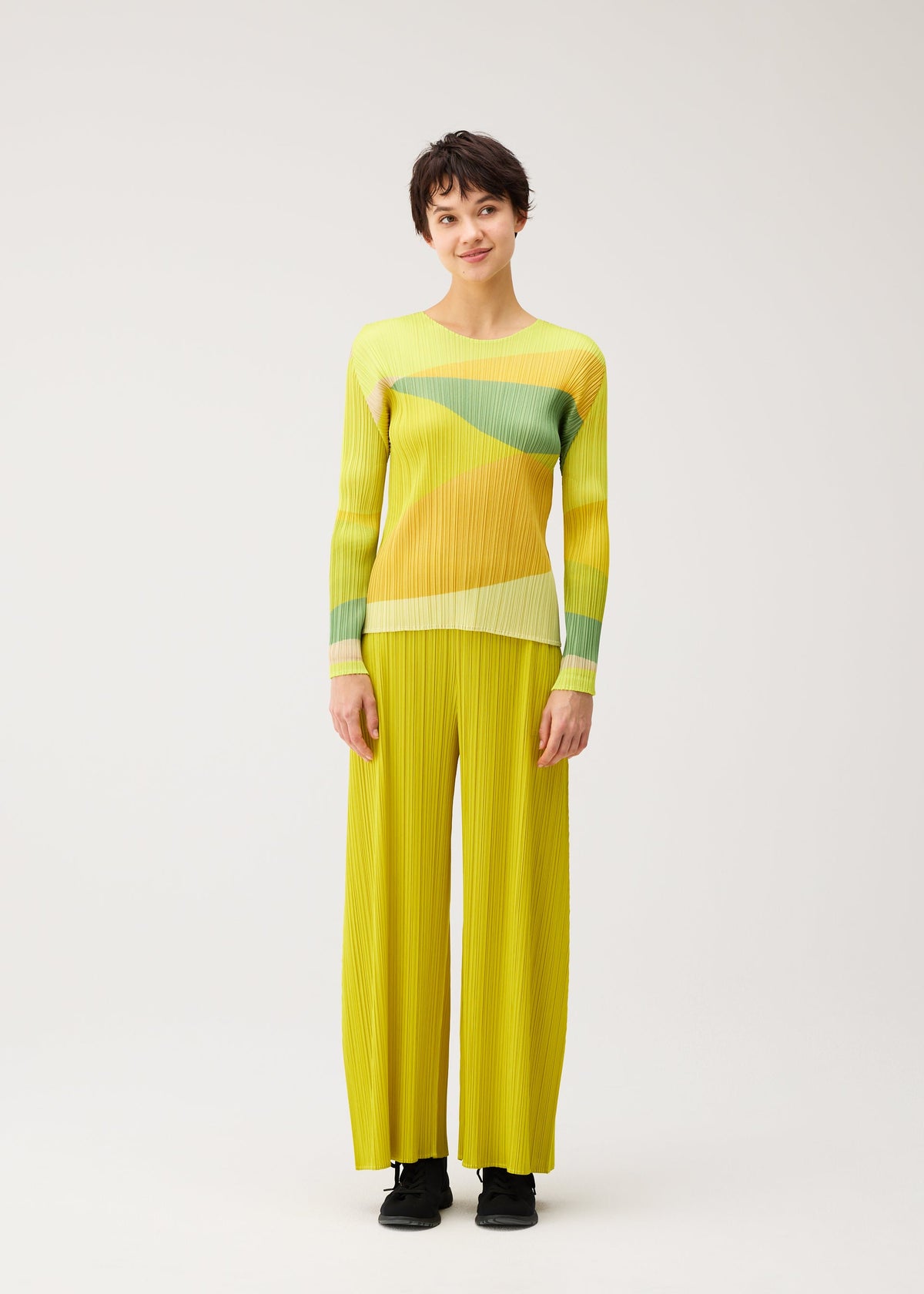 A model wears the PLEATS PLEASE ISSEY MIYAKE ORBIT orbit-shirt-yellow.