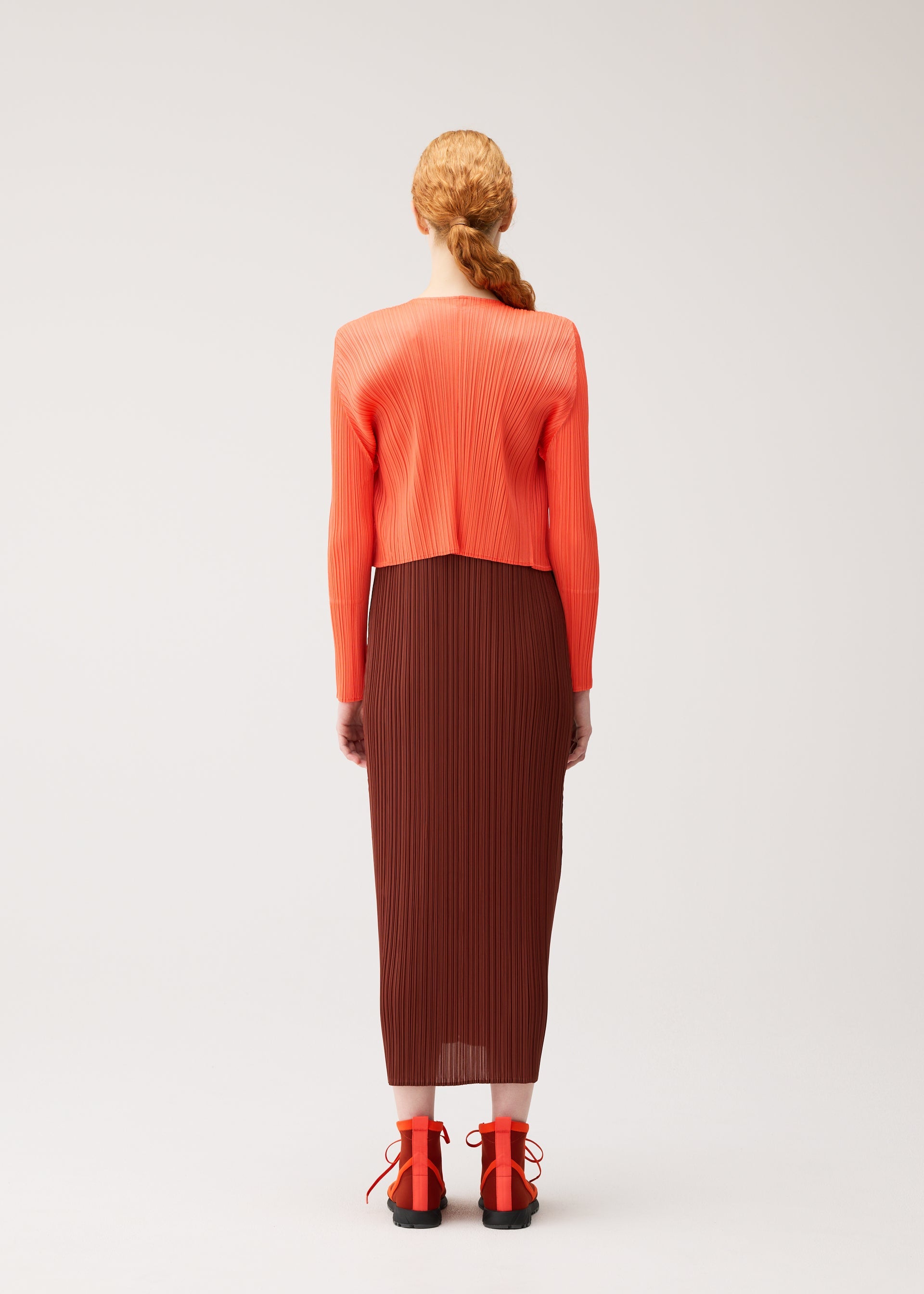 A model wears the PLEATS PLEASE ISSEY MIYAKE MONTHLY COLORS : SEPTEMBER cardigan.