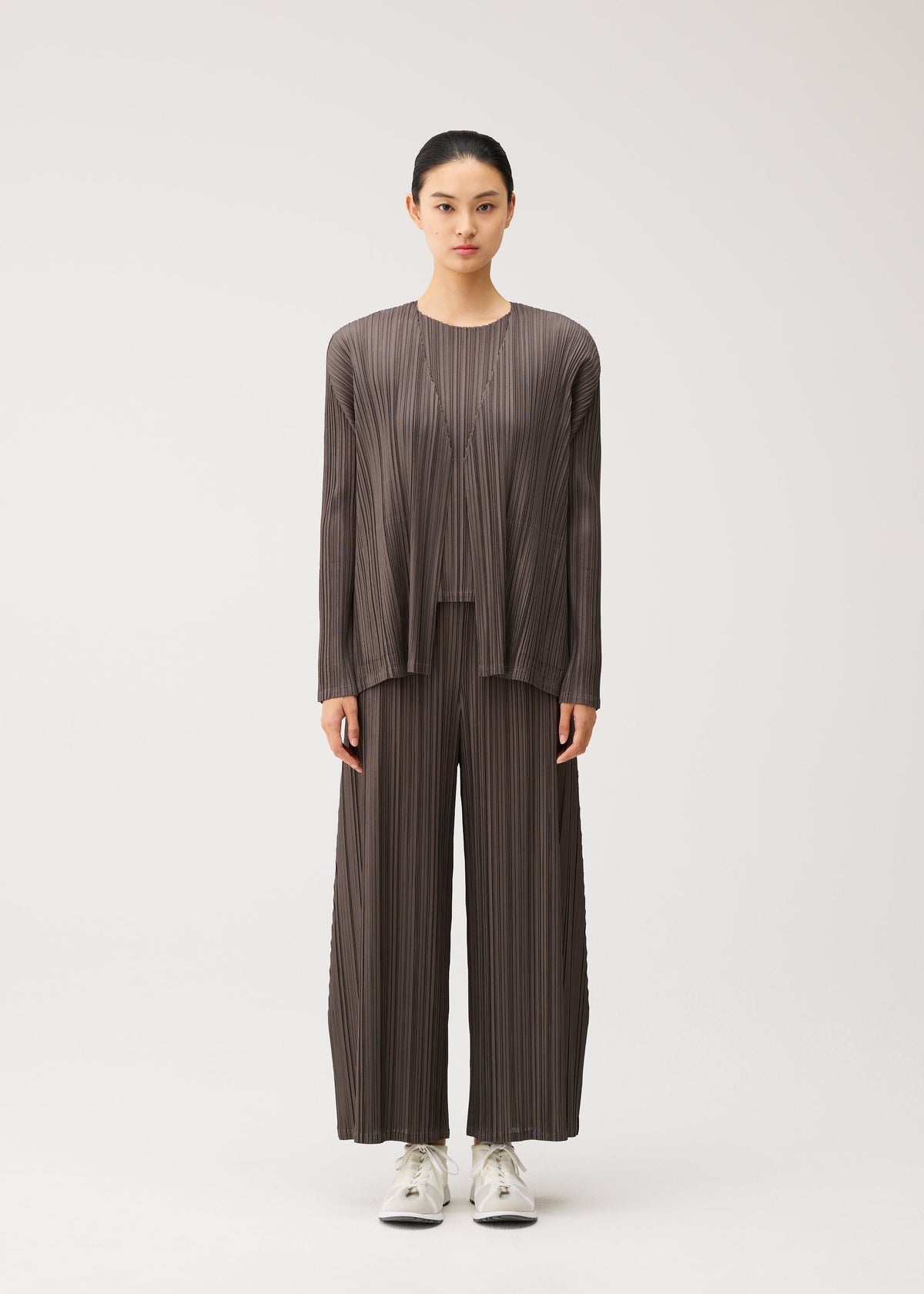 A model wears the PLEATS PLEASE ISSEY MIYAKE MELLOW PLEATS cardigan.