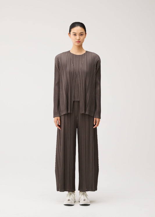 A model wears the PLEATS PLEASE ISSEY MIYAKE MELLOW PLEATS cardigan.