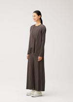 A model wears the PLEATS PLEASE ISSEY MIYAKE MELLOW PLEATS cardigan.