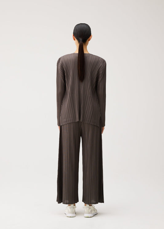 A model wears the PLEATS PLEASE ISSEY MIYAKE MELLOW PLEATS cardigan.
