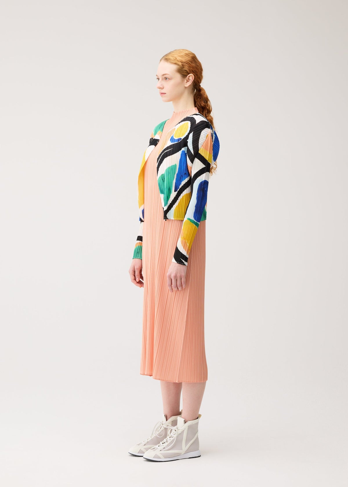 A model wears the PLEATS PLEASE ISSEY MIYAKE ROLL roll-cardigan-multi-1.