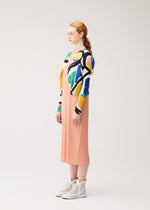 A model wears the PLEATS PLEASE ISSEY MIYAKE ROLL roll-cardigan-multi-1.