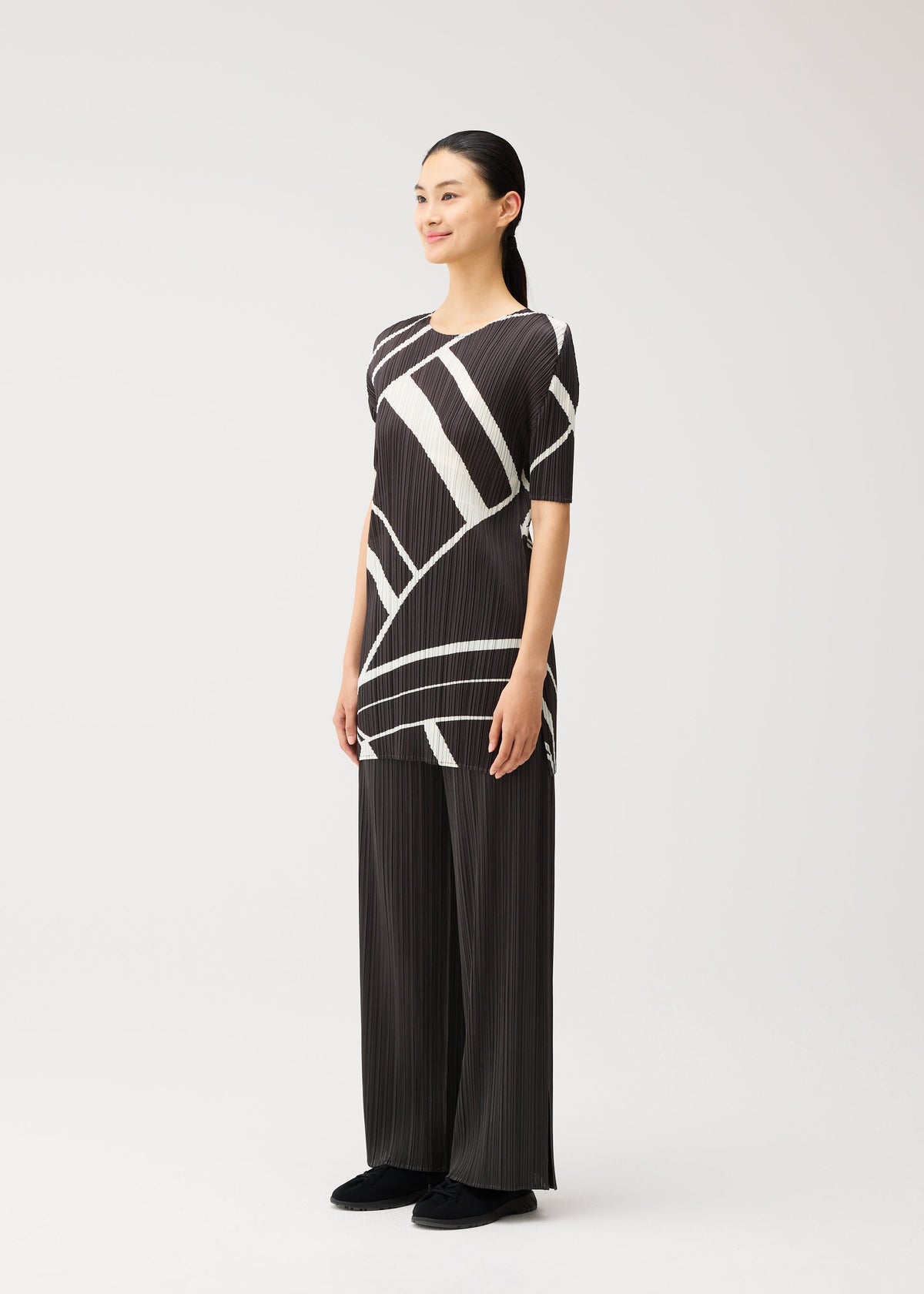 A model wears the PLEATS PLEASE ISSEY MIYAKE FOLD LINE fold-line-dress-off-white-1.