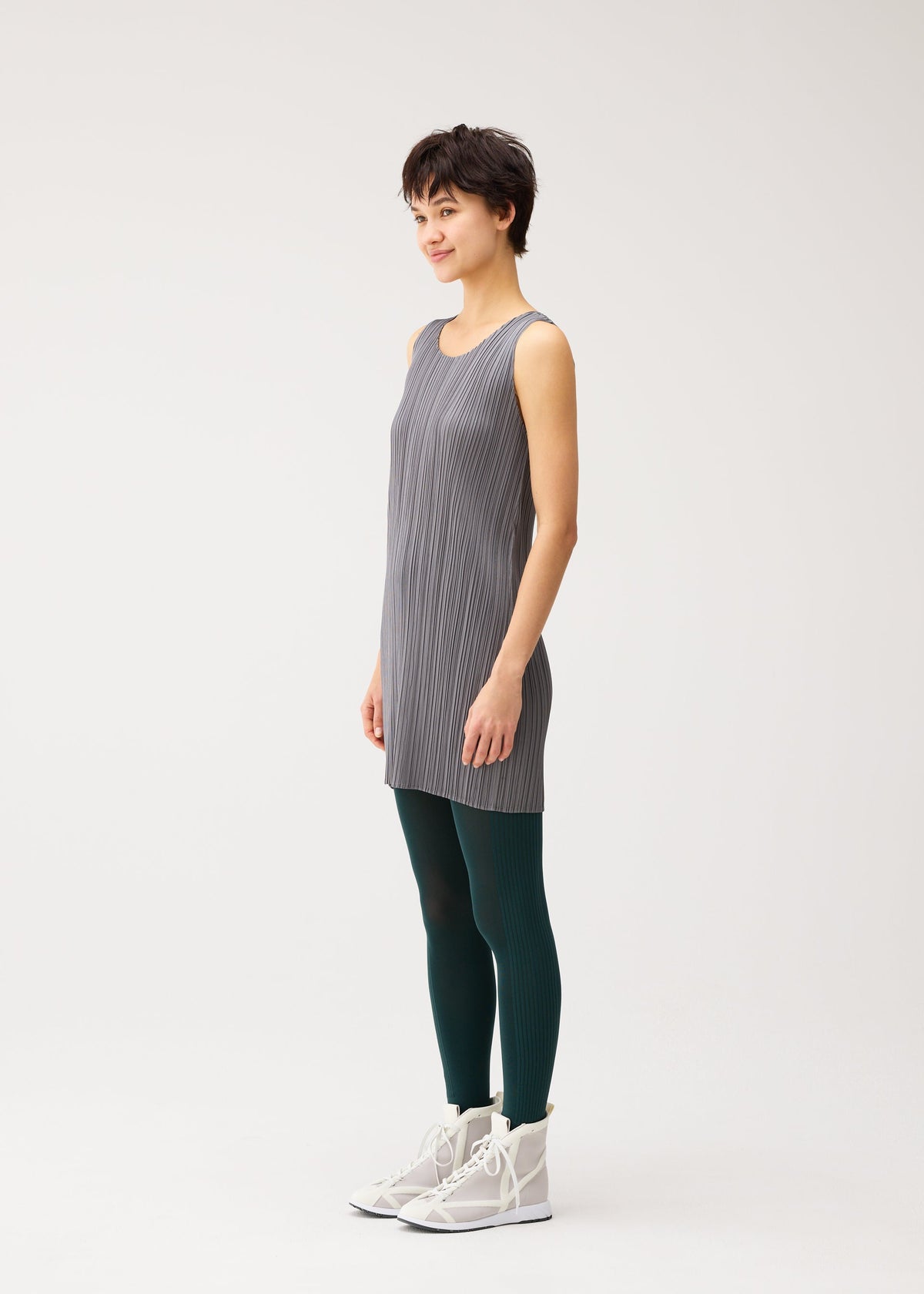 A model wears the PLEATS PLEASE ISSEY MIYAKE A-POC SKIN trousers.
