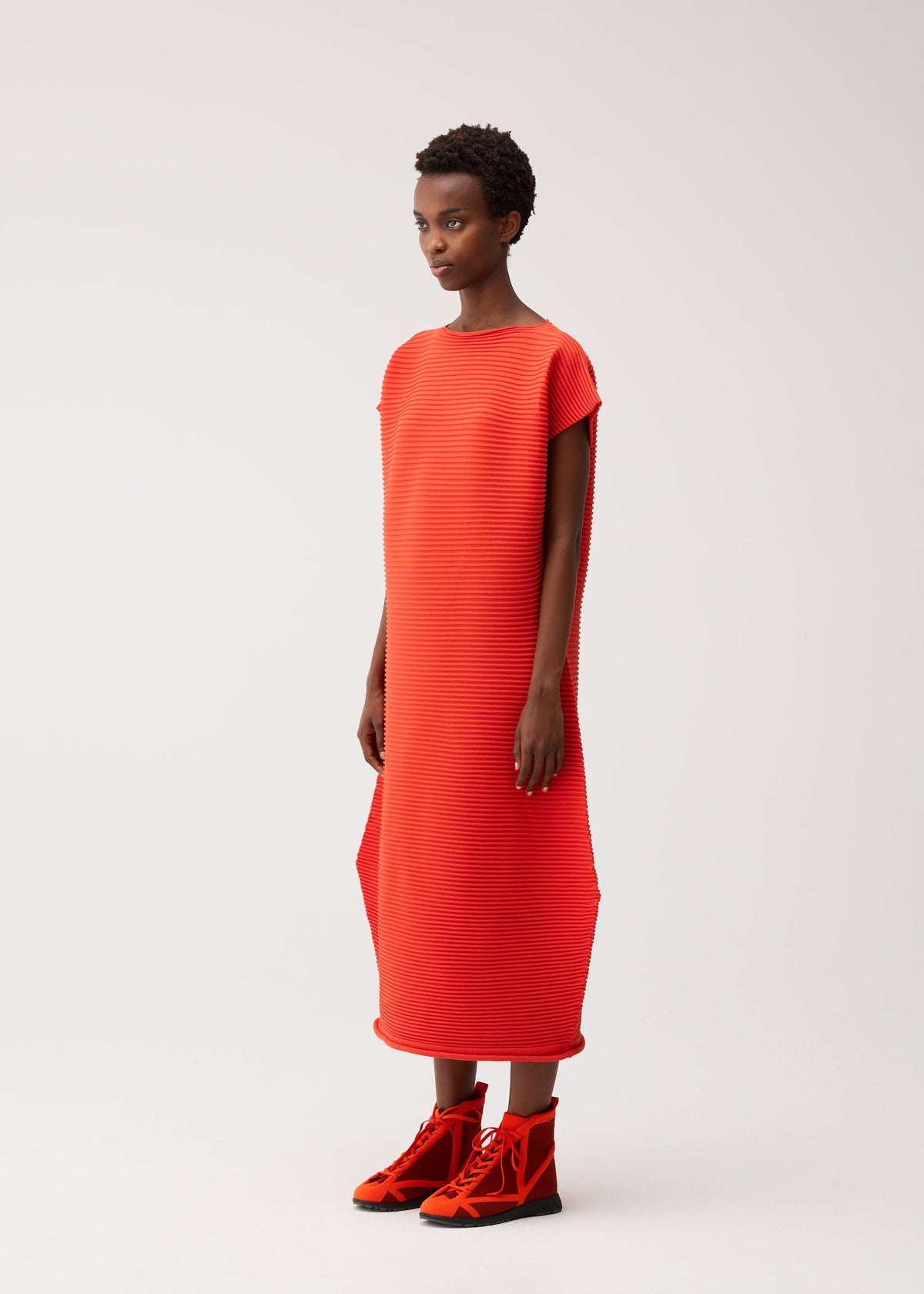 A model wears the PLEATS PLEASE ISSEY MIYAKE ZIG ZAG KNIT dress.