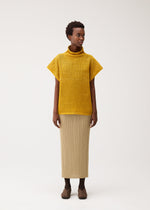 A model wears the PLEATS PLEASE ISSEY MIYAKE DOT KNIT dot-knit-shirt-ochre.
