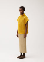 A model wears the PLEATS PLEASE ISSEY MIYAKE DOT KNIT shirt.