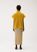 A model wears the PLEATS PLEASE ISSEY MIYAKE DOT KNIT shirt.