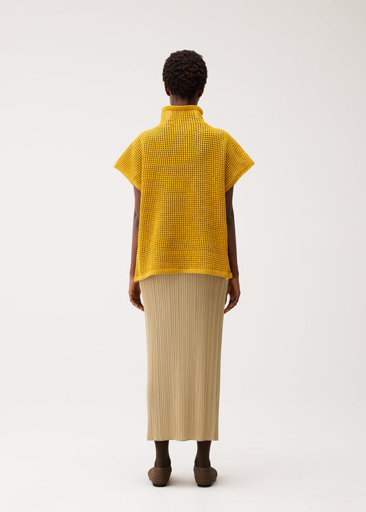 A model wears the PLEATS PLEASE ISSEY MIYAKE DOT KNIT shirt.