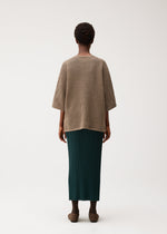 A model wears the PLEATS PLEASE ISSEY MIYAKE DOT KNIT shirt.