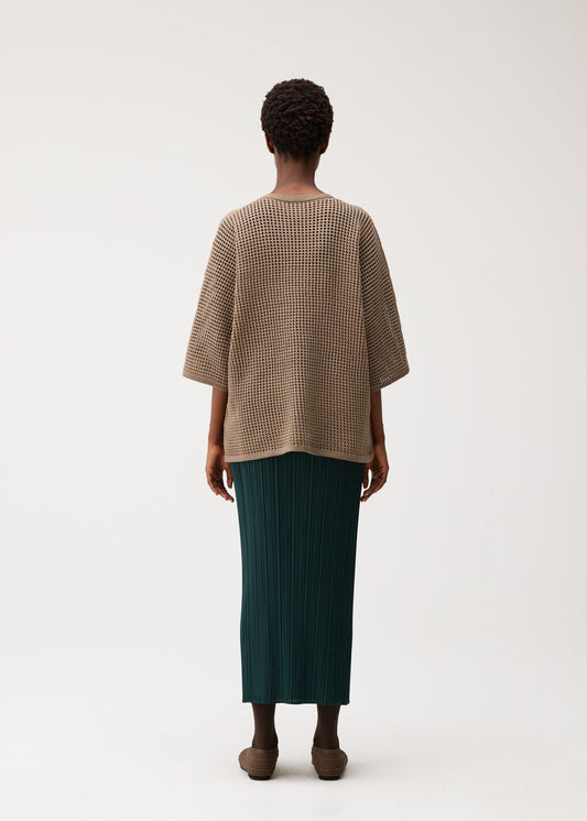 A model wears the PLEATS PLEASE ISSEY MIYAKE DOT KNIT shirt.