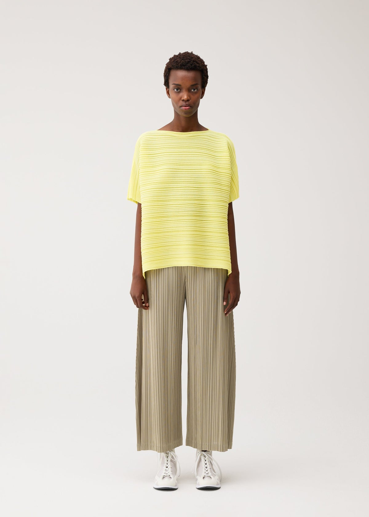 A model wears the PLEATS PLEASE ISSEY MIYAKE PAPER BOUNCE KNIT paper-bounce-knit-shirt-black-1.